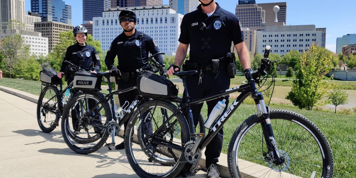 3 OSUPD officers stand near their bikes.