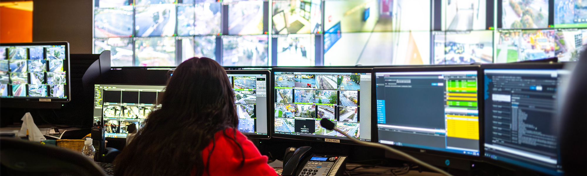 Interior view of the Communications Center at OSUPD headquarters. A number of screens and displays project camera feeds across campus