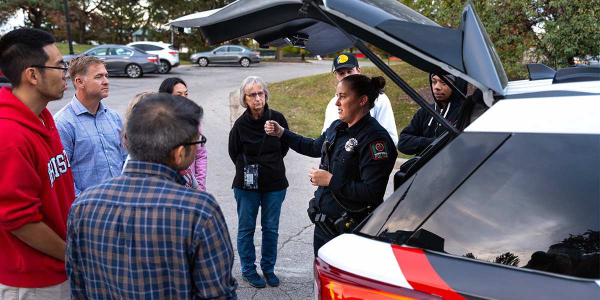 Police officer giving patrol vehicle tour to public