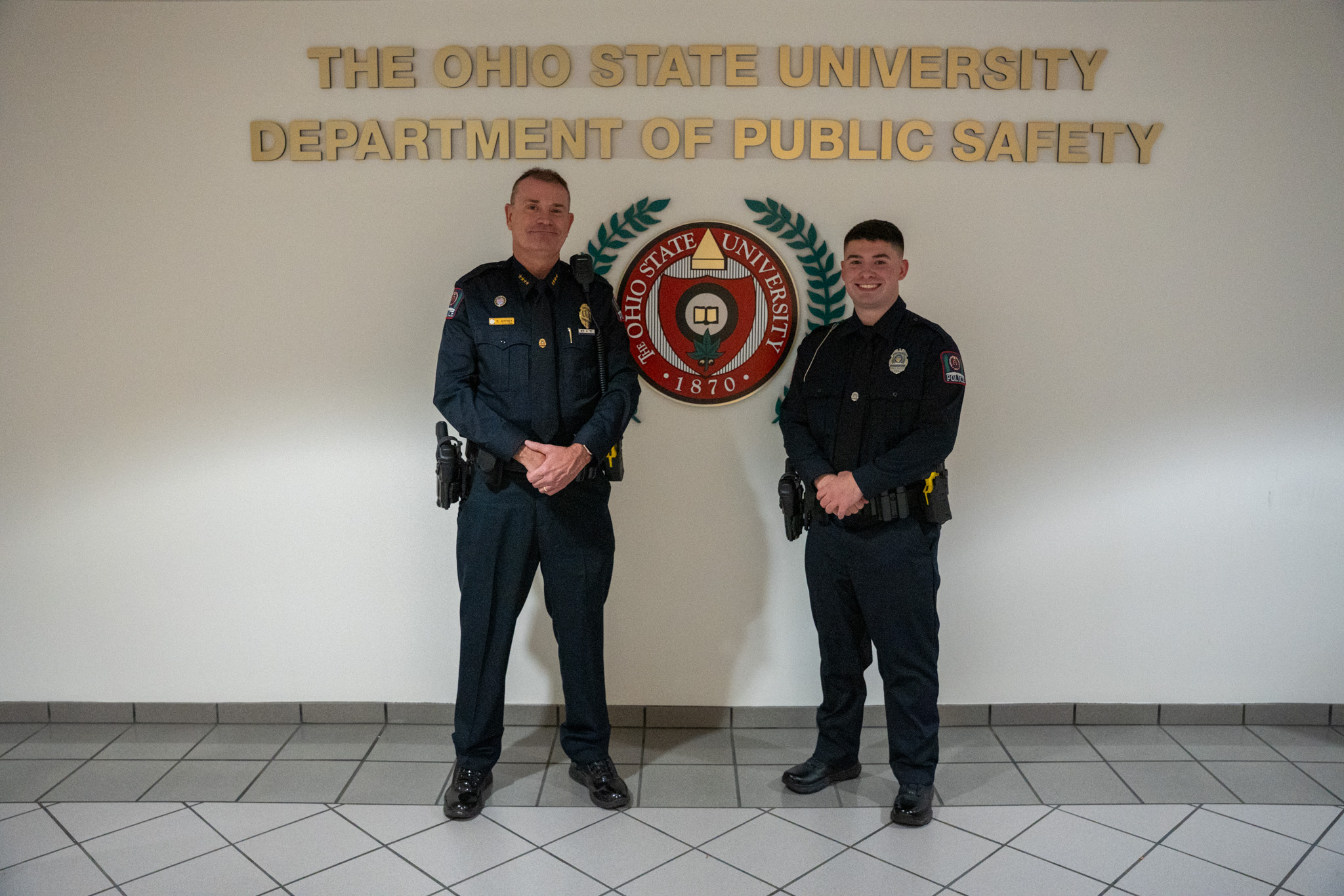 The Police Chief standing next to a new officer.