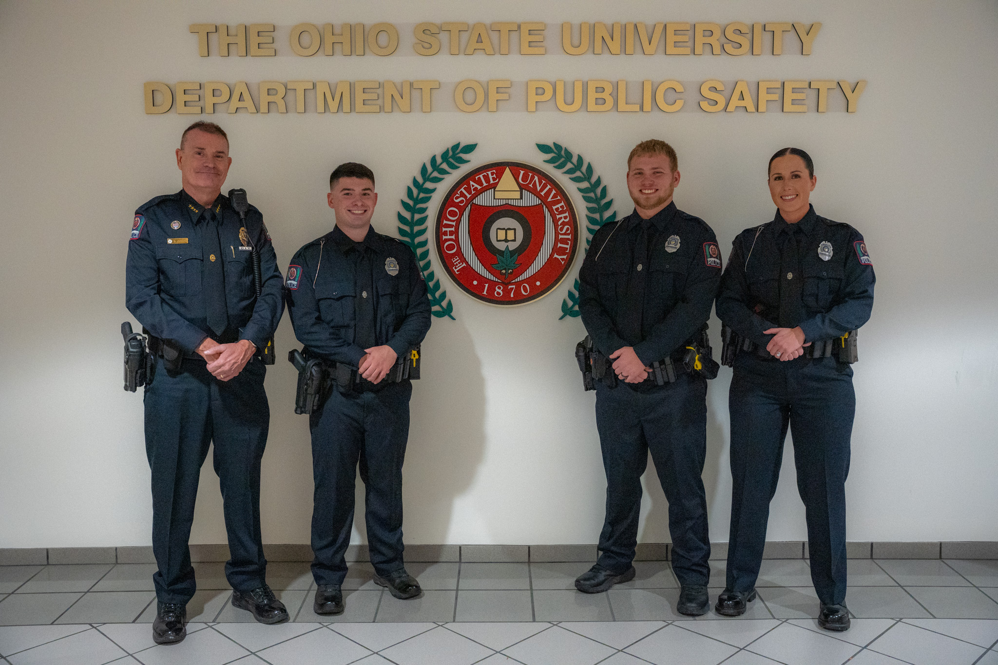 Three new officers standing with the police chief.