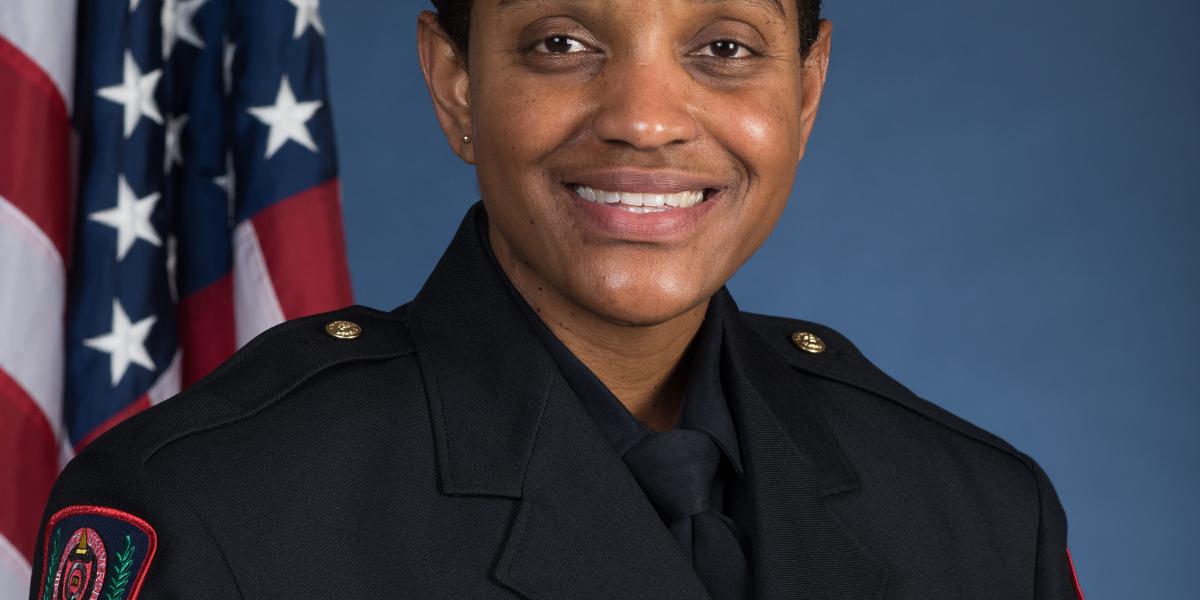 formal headshot of Kimberly Spears-McNatt, seated in front of an American flag