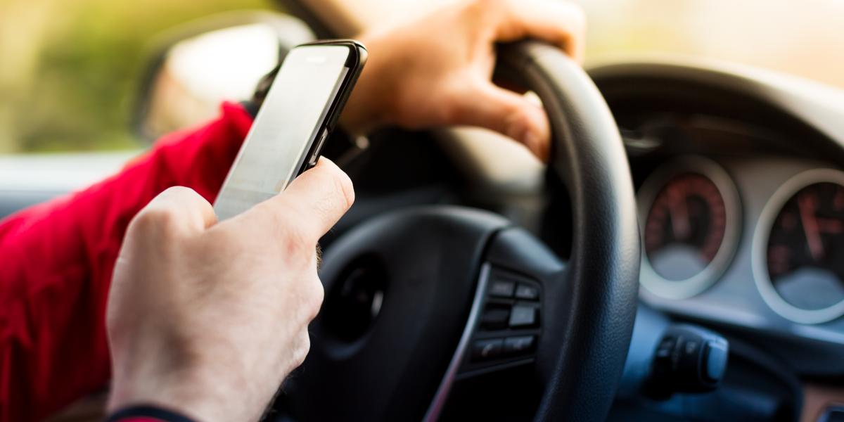 A driver looking at his phone behind the wheel