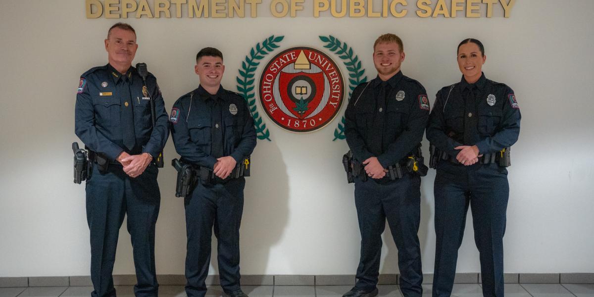 Three new officers standing with the police chief.