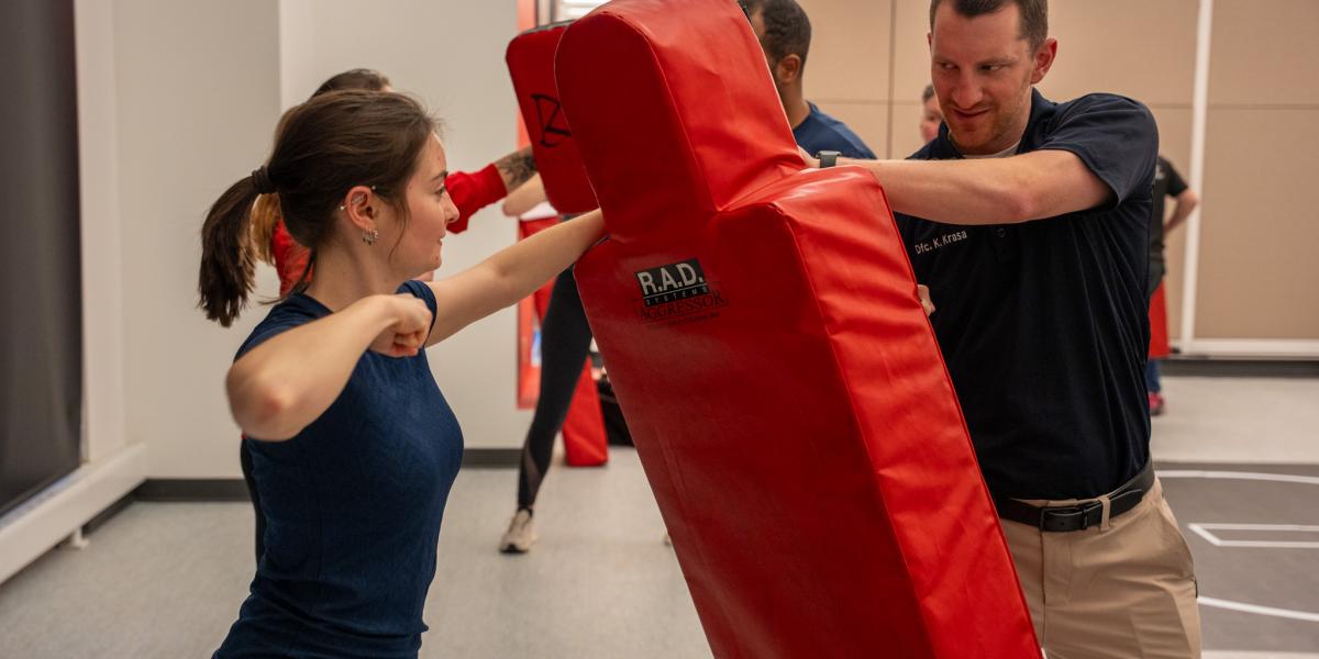 A woman is shown hitting a mat