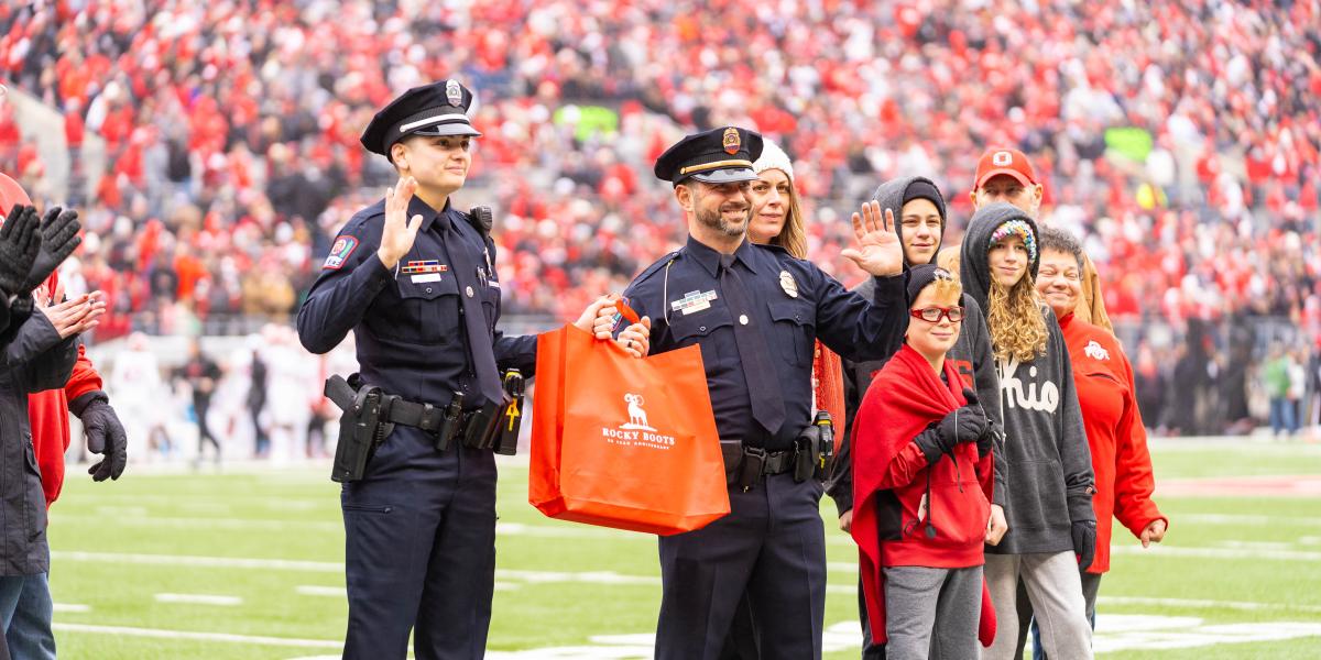 Lt. Shankle and Officer Ward waving at a crowd while smiling.