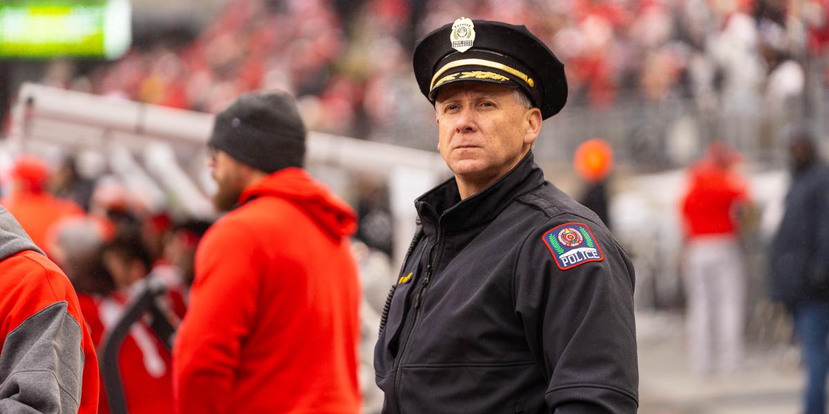 Deputy Chief Whiteside stands at the game looking at the crowd.