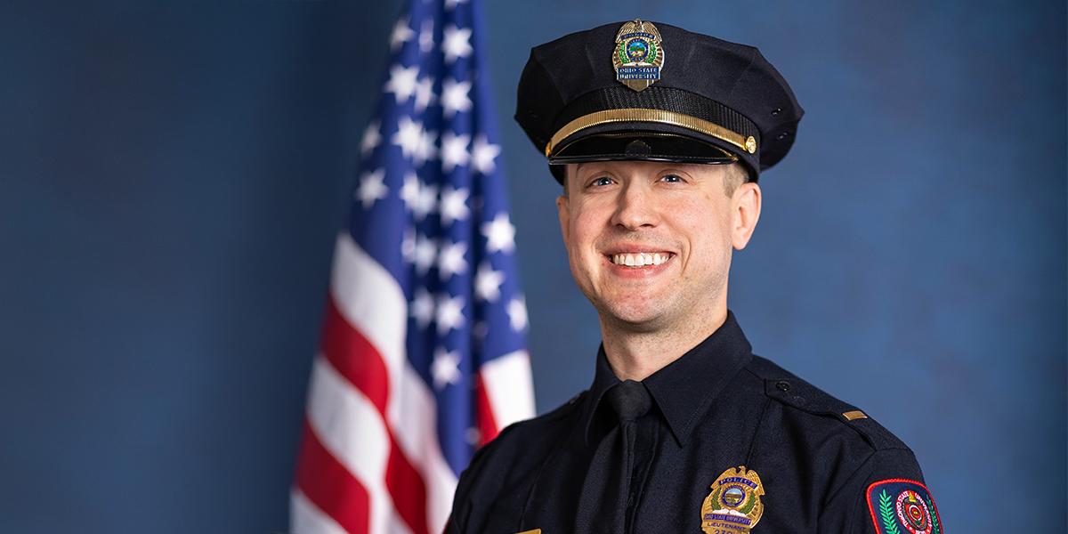 Alan Horujko headshot in front of American flag