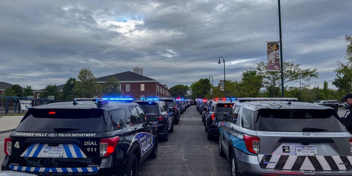 A line of first responder vehicles with their blue lights on.