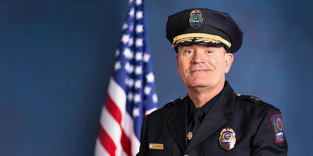 deputy cheif dennis jeffrey in front of american flag