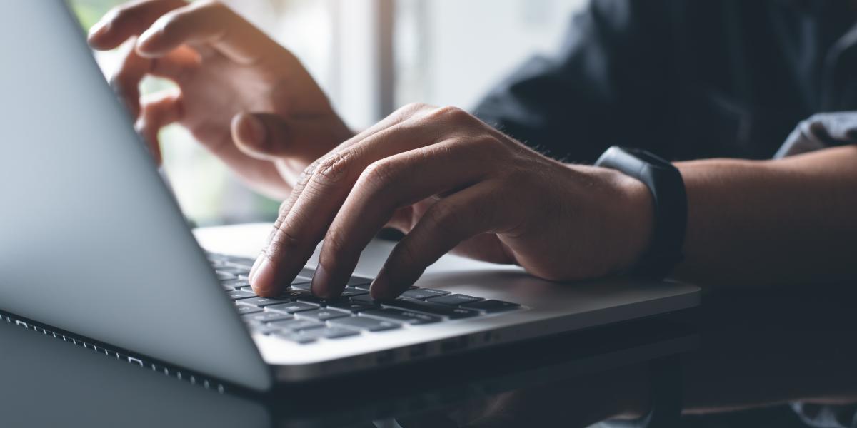 hands typing on laptop