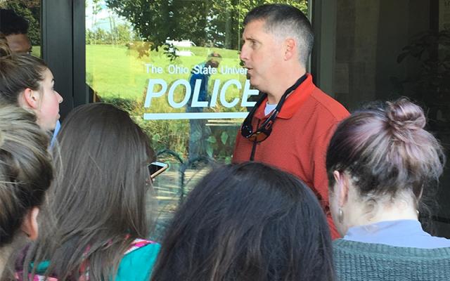 Police officer talks to journalism students during mock crime scenario