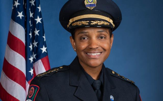 Chief Spears-McNatt next to American flag