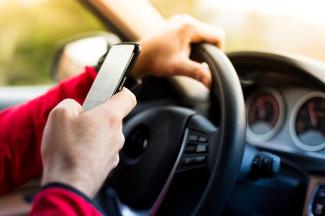 A driver looking at his phone behind the wheel