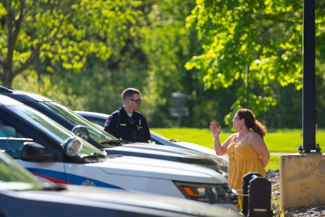police officer helps female near cars in parking lot
