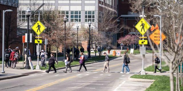 pedestrians walking through crosswalk near construction area