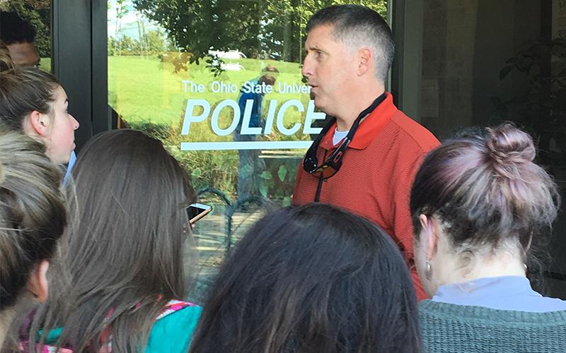Police officer talks to journalism students during mock crime scenario