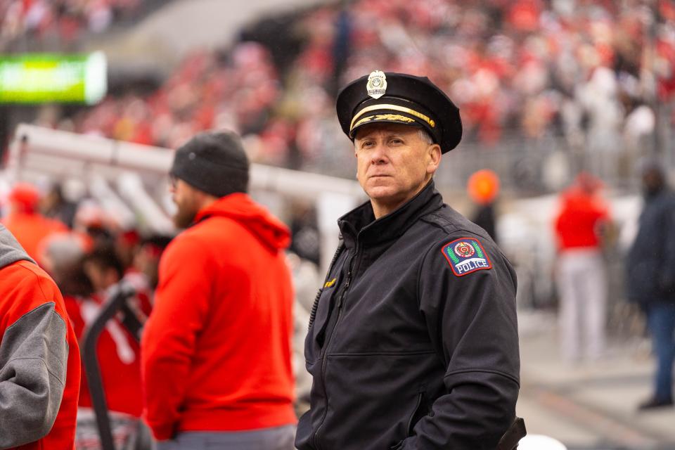 Deputy Chief Whiteside stands at the game looking at the crowd.
