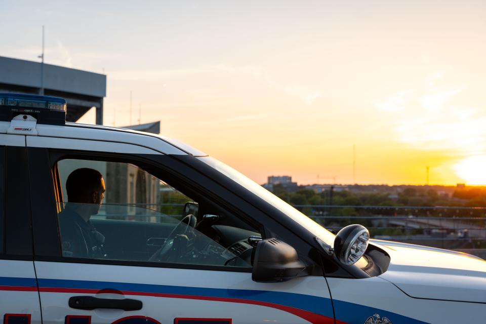 Police cruiser on the top level of a parking deck looking out over a sunset